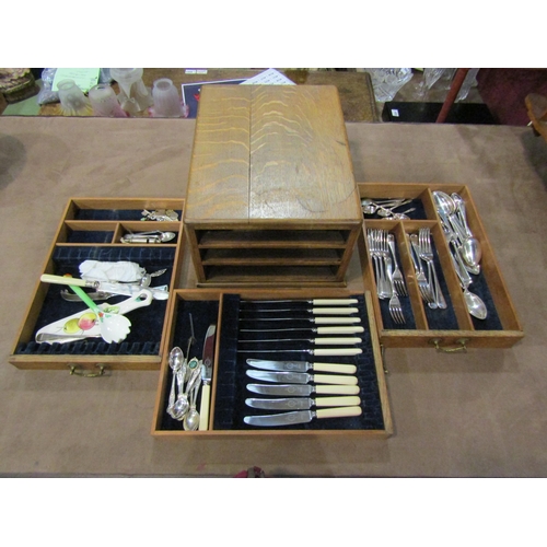 4012 - An early 20th Century oak three drawer cutlery canteen with contents