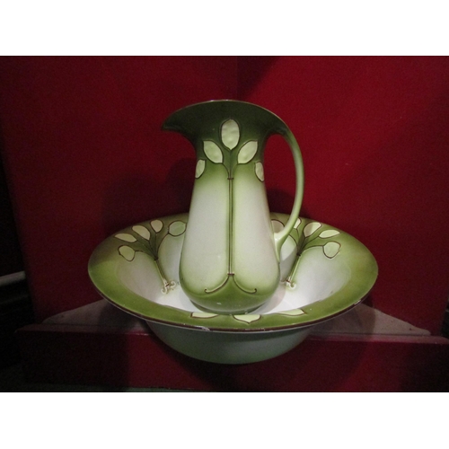 4053 - An Art Nouveau era wash jug and bowl, green tint with leaf design