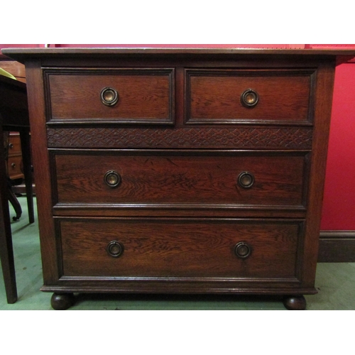 4095 - A circa 1920 oak chest of small proportions, the two short over two long drawers with blind fret dec... 