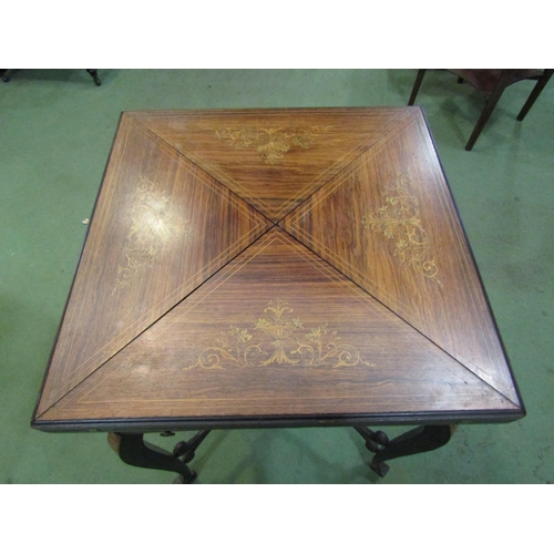 4119 - An Edwardian walnut marquetry inlaid envelope card table, the four-fold top over single frieze drawe... 