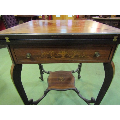 4119 - An Edwardian walnut marquetry inlaid envelope card table, the four-fold top over single frieze drawe... 