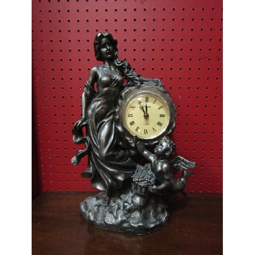 4131 - A figural clock, Roman numerated chapter ring flanked by female and cherub, quartz movement