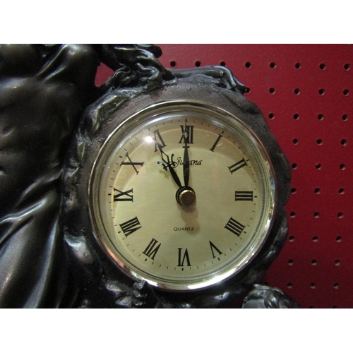 4131 - A figural clock, Roman numerated chapter ring flanked by female and cherub, quartz movement