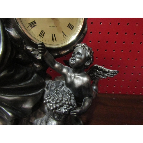 4131 - A figural clock, Roman numerated chapter ring flanked by female and cherub, quartz movement