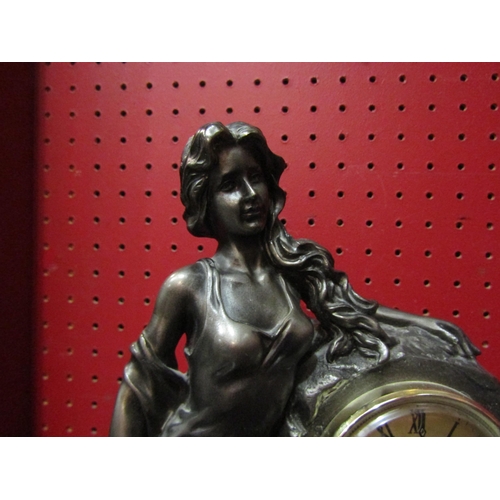 4131 - A figural clock, Roman numerated chapter ring flanked by female and cherub, quartz movement