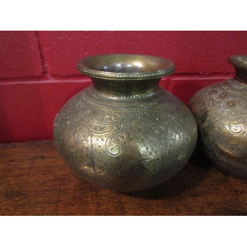 4179 - A pair of Eastern brass pots of bulbous form engraved with figures and animals, 17cm tall approx.