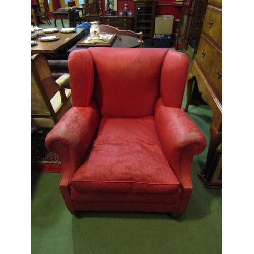 4184 - A Circa 1920 wing back club armchair with red upholstery on bun fore feet and castors