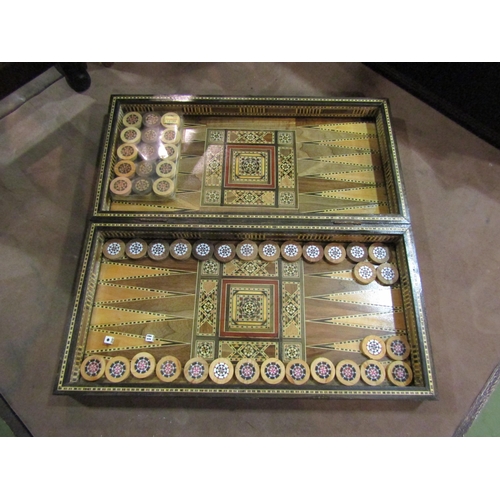 4228 - A folding Eastern inlaid backgammon board with inlaid counters and dice, open 50cm x 50cm