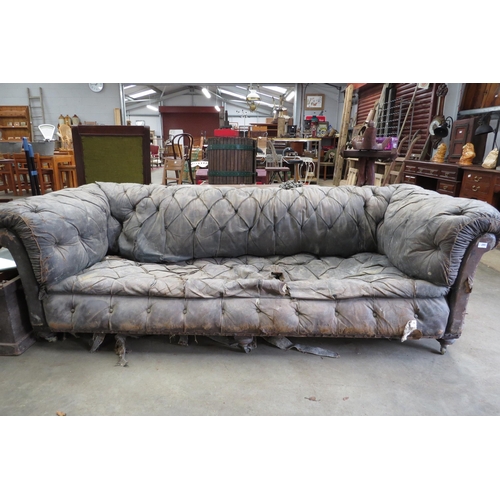 2001 - A Victorian well worn leather sofa on three turned front legs for restoration