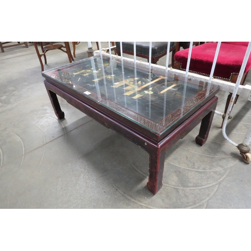 2142 - A Chinese carved glass top coffee table