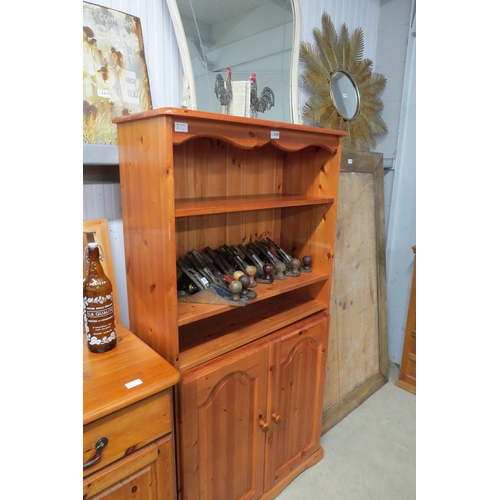 2220 - A modern pine bookcase, shelved top over two door cupboard