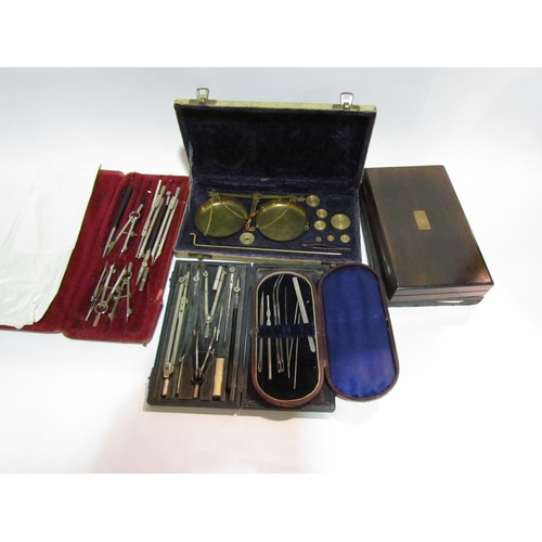 4333 - A selection of cased compass sets and a set of brass weighing scales