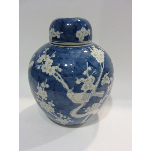 4445 - A blue and white ginger jar decorated with birds and prunus, approximately 26cm tall