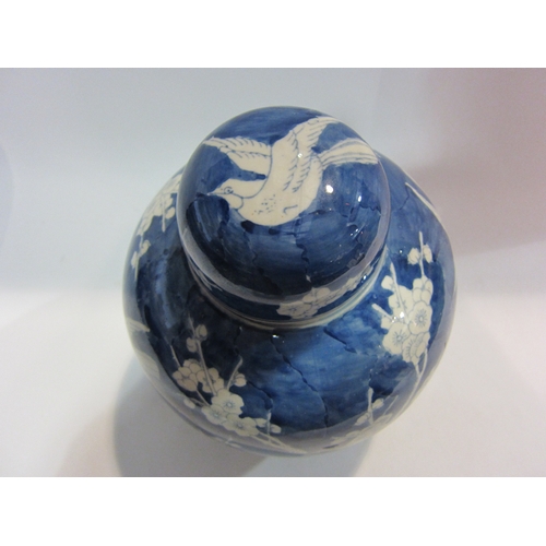 4445 - A blue and white ginger jar decorated with birds and prunus, approximately 26cm tall