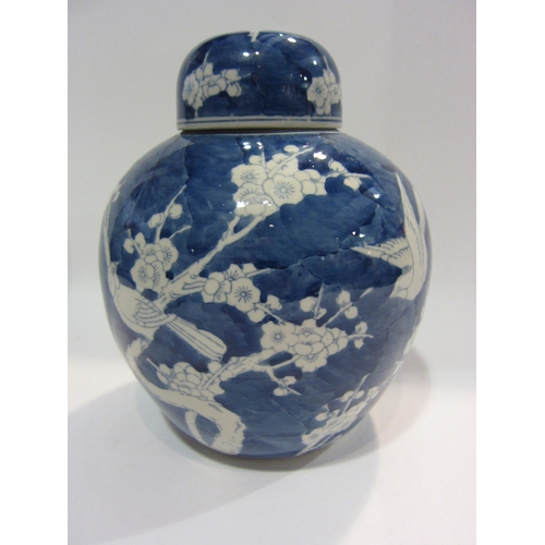 4445 - A blue and white ginger jar decorated with birds and prunus, approximately 26cm tall