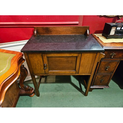 4072 - Circa 1920 an oak marble top washstand with raised back over a single door cupboard and towel rail o... 