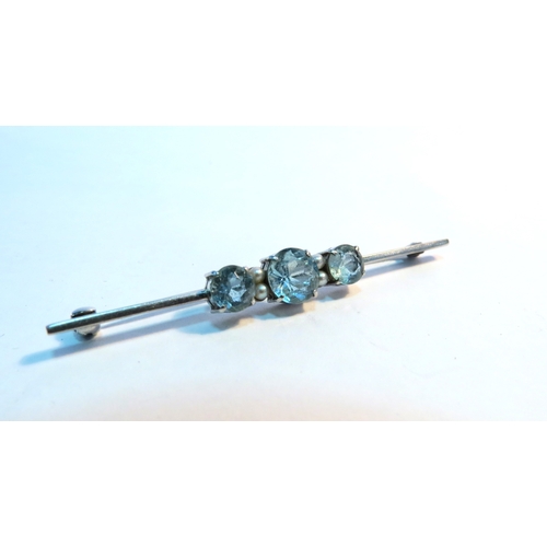 1262 - A white gold three stone blue zircon and pearl bar brooch, stamped 9ct, 3g