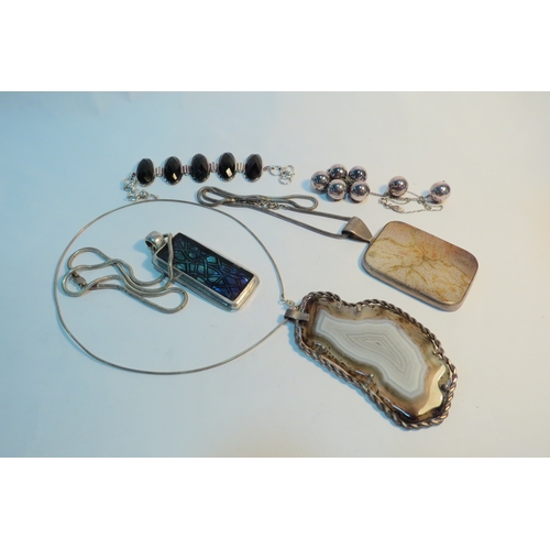 1334 - A black onyx bracelet and three modernistic pendants on chains including agate example and a boxed n... 