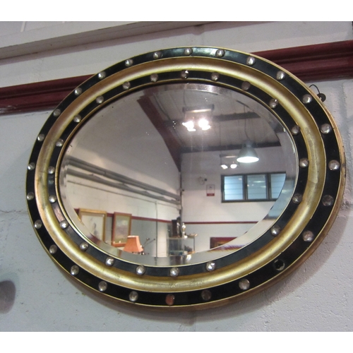 1028 - A Regency style oval wall mirror, gilt and ebonised with gem style roundels, 44cm x 54cm total