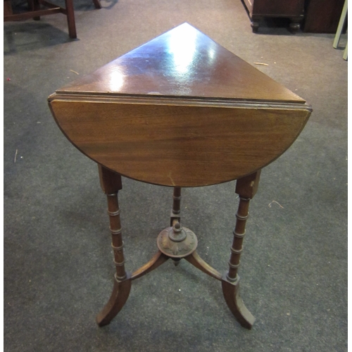 1091 - An Edwardian mahogany cloverleaf occasional table with folding leaves, on ring-turned supports, outs... 