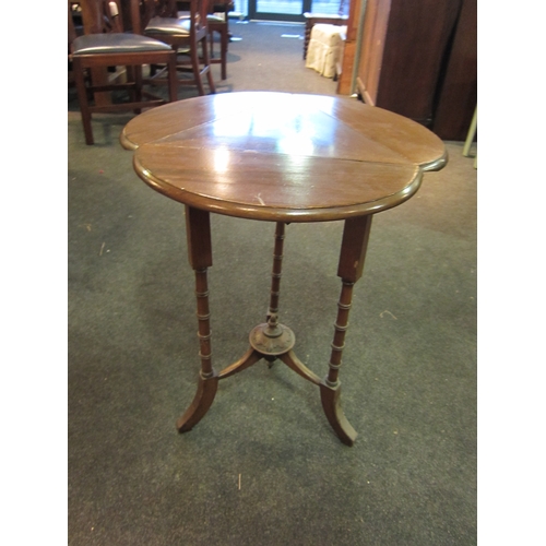 1091 - An Edwardian mahogany cloverleaf occasional table with folding leaves, on ring-turned supports, outs... 