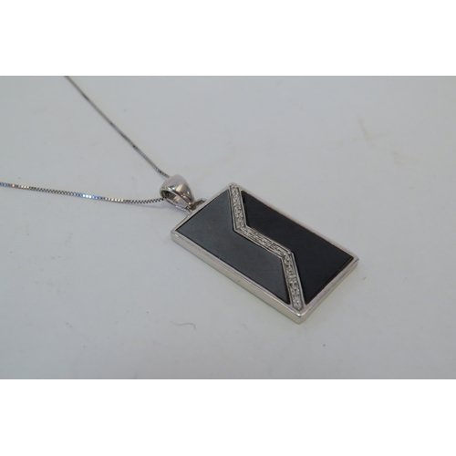 1406 - A 9ct white gold onyx and diamond set rectangular pendant on chain, 6g