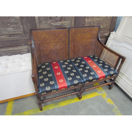 2247 - A 1930's bergere settee, bobbin supports, upholstered seats