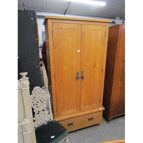 2250 - A light oak wardrobe, two doors over single drawer base