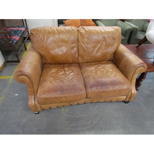 2258 - A nicely worn tan leather two seater cottage sofa