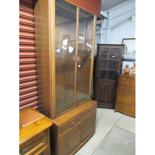 2062 - An Ercol full height glass two door cabinet on cupboard