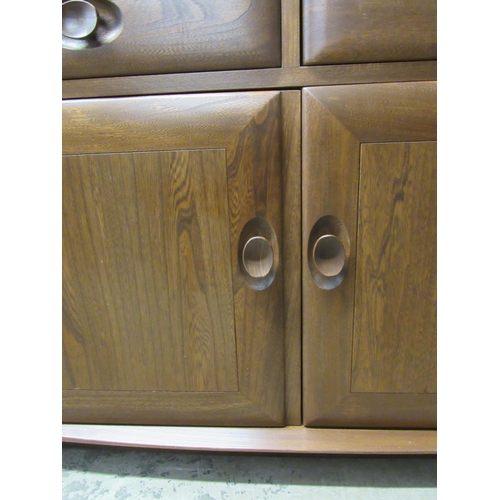 2062 - An Ercol full height glass two door cabinet on cupboard