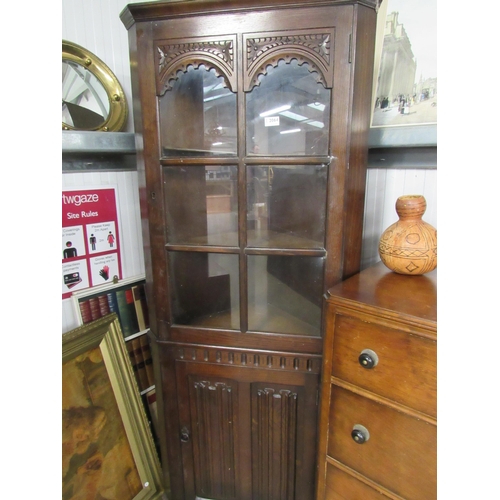 2064 - An oak corner cupboard with linen fold doors