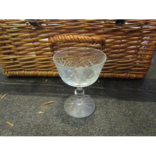 1163 - A wicker basket containing 12 cut glass bowls and 10 wine glasses