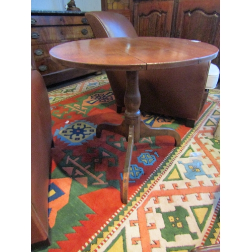 1020 - A Georgian oak wine table, the circular top over turned column to a tripod base with downturned legs... 