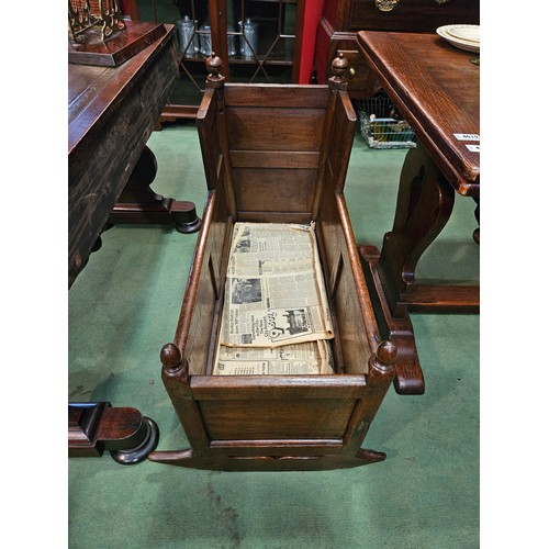 4215 - An 18th Century panelled oak cradle/log box with turned finial decoration on sledge foot end support... 