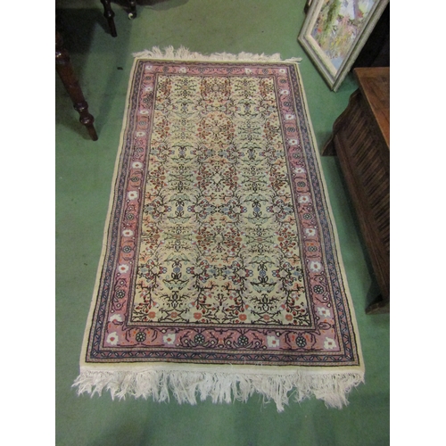 4465 - A Persian style rug, the cream ground decorated with floral designs and multiple borders with tassel... 