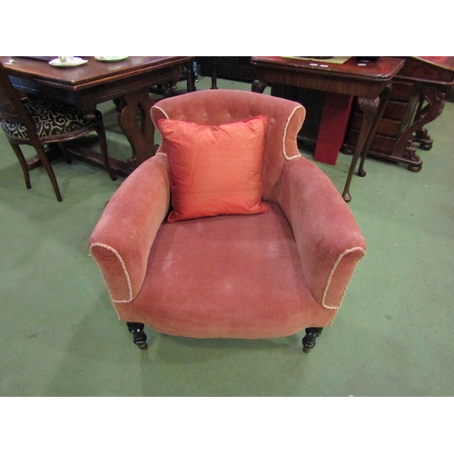 4077 - A late Victorian peach upholstered button back armchair on turned ebonised legs and castors with sca... 