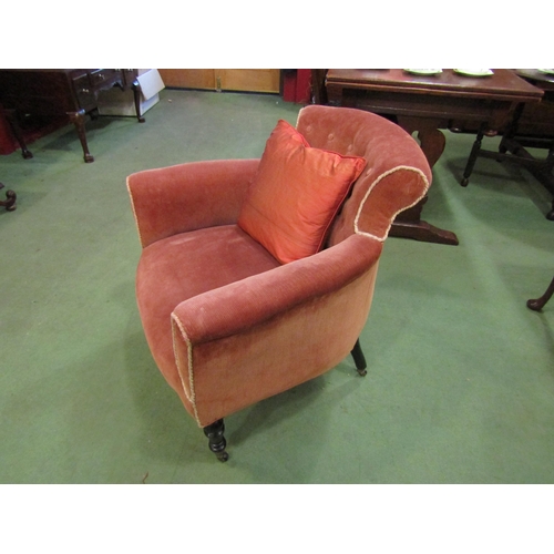 4077 - A late Victorian peach upholstered button back armchair on turned ebonised legs and castors with sca... 