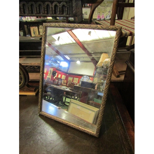 4204 - An Edwardian easel back mirror with ornate carved frame 38 x 27cms