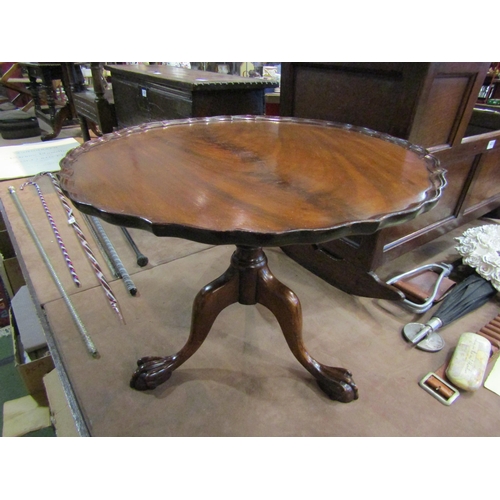 4219 - A George III style flame mahogany occasional table, the pie crust edge top over a turned column and ... 