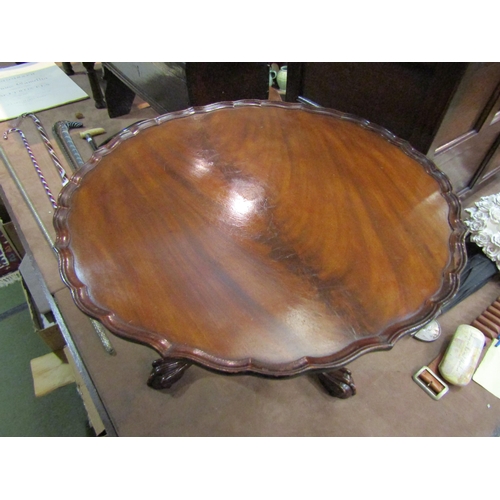 4219 - A George III style flame mahogany occasional table, the pie crust edge top over a turned column and ... 