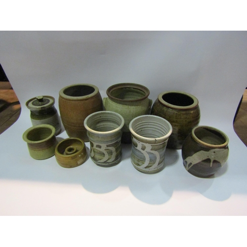 4279 - A pair of Studio pottery plant pots raised on three feet, lidded cannister a/f, jars etc (9)