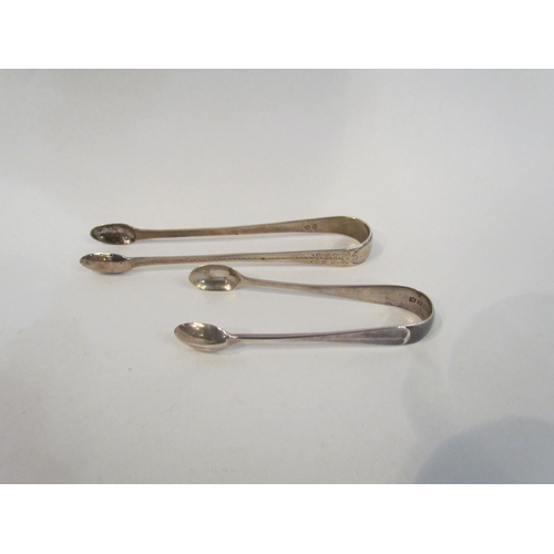 4382 - Two pairs of silver sugar tongs and a silver spoon (3)