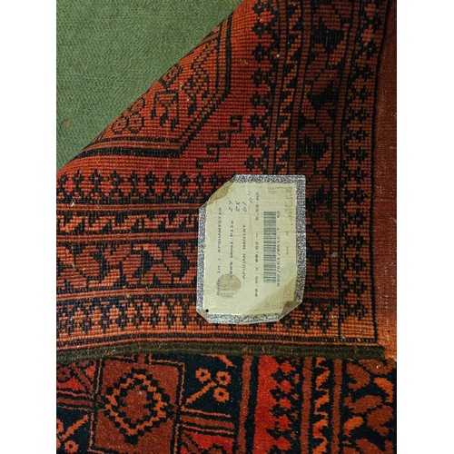 4175 - An Afghanistan wool rug, red ground with multiple borders, tasselled ends, 100cm x 64cm