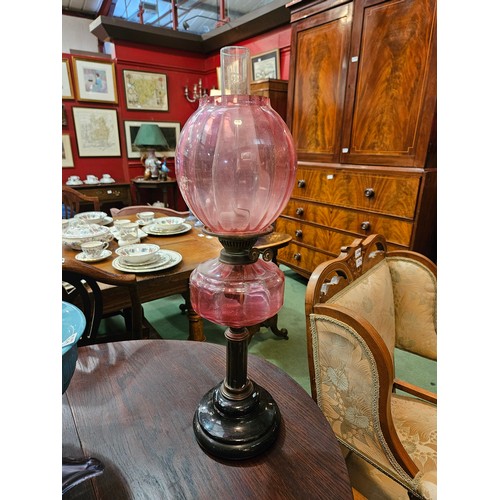 4177 - A Duplex oil lamp with pink shade and reservoir