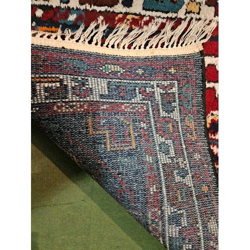 4196 - A Moroccan style rug, red and blue ground, tasselled ends,198cm x 95cm