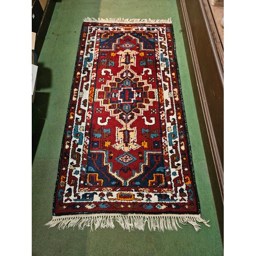 4196 - A Moroccan style rug, red and blue ground, tasselled ends,198cm x 95cm