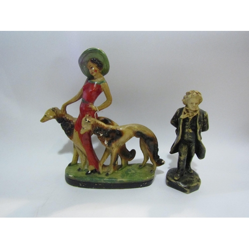 4446 - A circa 1930's plaster figure of lady with dogs and a figure of Beethoven, 34cm and 25cm tall