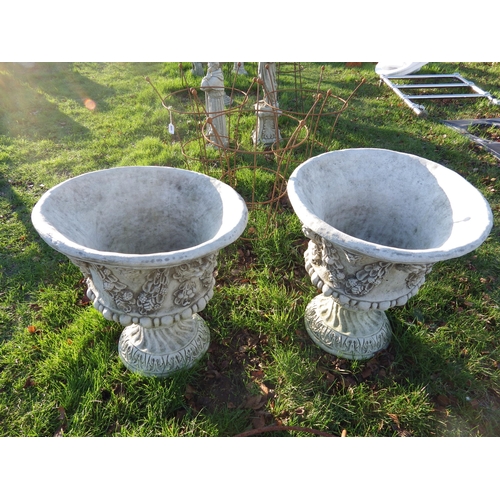 7095 - A pair of decorative composition urns on socles, 24