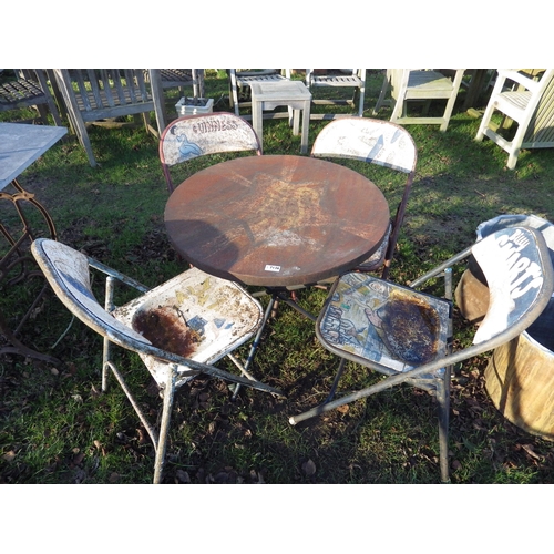 7136 - A circular metal garden table and four chairs, painted detail including Guinness and Billy Smart